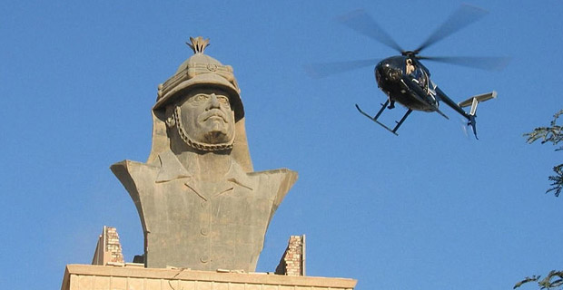 Blackwater helicopter over a bust of Saddam Hussein in Baghdad, Iraq. The mercenary group was implicated in the 2007 shooting in Baghdad's Nisour Square that killed 17 unarmed civilians, including women and children. Photo: Wikimedia Commons